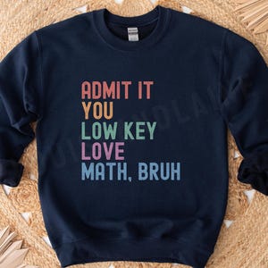 May include: Navy blue sweatshirt with the text "Admit it you low key love math, bruh" in rainbow colors.