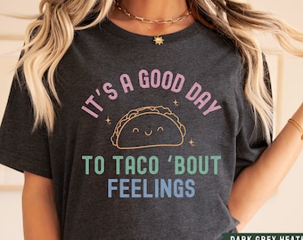 May include: Dark grey heather t-shirt with a graphic of a smiling taco and the text "It's a good day to taco 'bout feelings."
