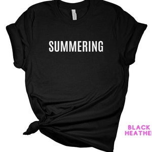 May include: Black heather t-shirt with the text "SUMMERING" printed in white on the front.