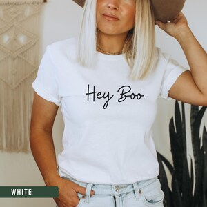 May include: White t-shirt with the text "Hey Boo" written in black cursive script.