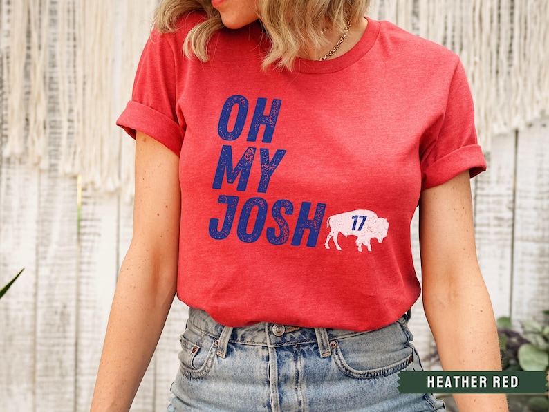 May include: Heather red t-shirt with the text "Oh My Josh" in blue and a white buffalo with the number "17" on it.