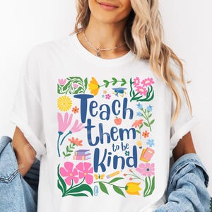 May include: White t-shirt with a colorful floral design and the text "Teach them to be kind".