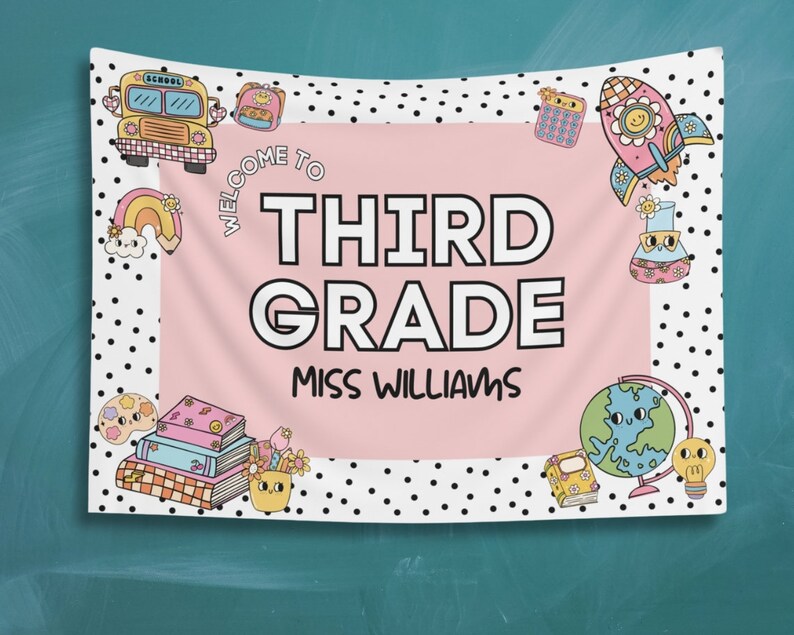 May include: A pink and white welcome banner with black polka dots. The banner says "Welcome to Third Grade Miss Williams". The banner is decorated with cartoon images of a school bus, a rocket ship, a globe, books, and a paint palette.