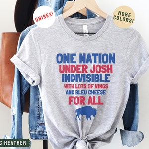 May include: A gray t-shirt with the text "One Nation Under Josh Indivisible with lots of wings and bleu cheese for all" in red, blue, and white. A blue buffalo silhouette is below the text.
