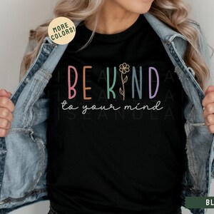May include: Black t-shirt with the text "BE KIND to your mind" in colorful letters with a flower graphic.