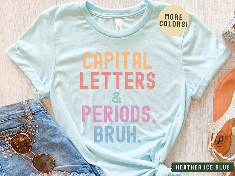 Puede incluir: Una camiseta azul claro con el texto "CAPITAL LETTERS & PERIODS, BRUH." en colores arco&iacute;ris. El texto est&aacute; en una fuente divertida y casual. La camiseta est&aacute; hecha de un material suave y c&oacute;modo y es perfecta para el uso diario.