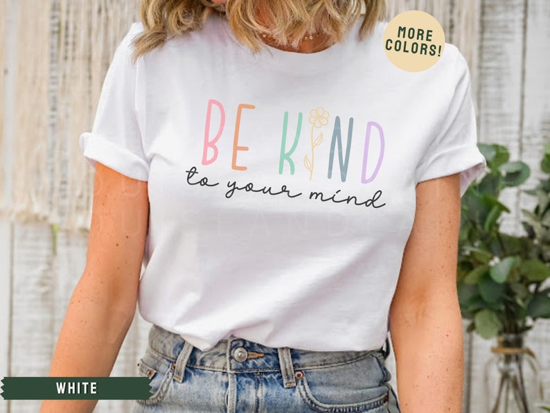 May include: White t-shirt with a colorful graphic that says "Be Kind to your mind" with a flower illustration.