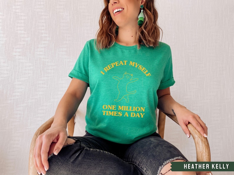 May include: A green t-shirt with a yellow graphic of a cat and the text "I repeat myself one million times a day".