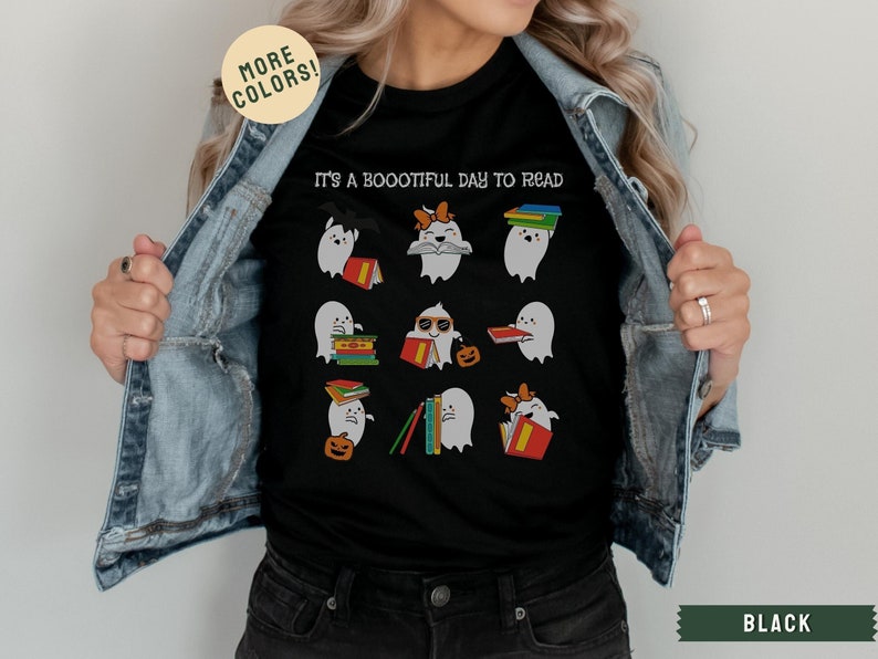 May include: Black t-shirt featuring a graphic of ghosts reading books. The text on the shirt reads "It's a Boootiful Day to Read".
