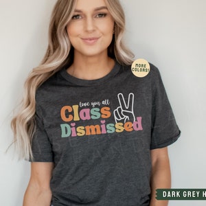 May include: Dark grey heather t-shirt with the text "Love you all Class Dismissed" in colorful letters with a peace sign.