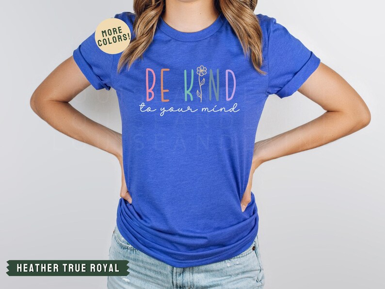 May include: A royal blue t-shirt with the text "BE KIND to your mind" in rainbow colors. The text is surrounded by a flower graphic.