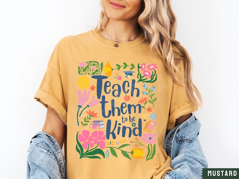 May include: Mustard yellow t-shirt with a floral design and the text "Teach them to be kind".