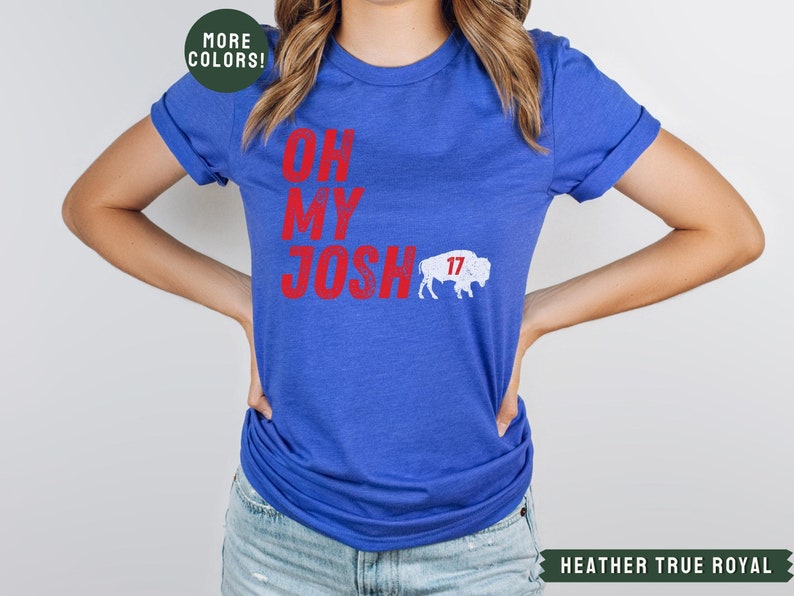 May include: A royal blue t-shirt with the text "Oh My Josh" in red and a white buffalo with the number 17 on it.