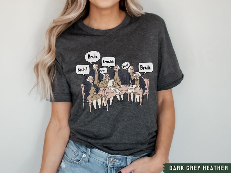 Peut inclure: T-shirt gris fonc&eacute; chin&eacute; avec un motif repr&eacute;sentant les P&egrave;res fondateurs assis autour d'une table avec des bulles de dialogue qui disent "Bruh." et "Bruh?"