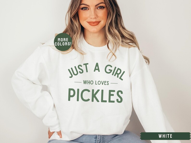 May include: White sweatshirt with the text "Just a girl who loves pickles" in green lettering.