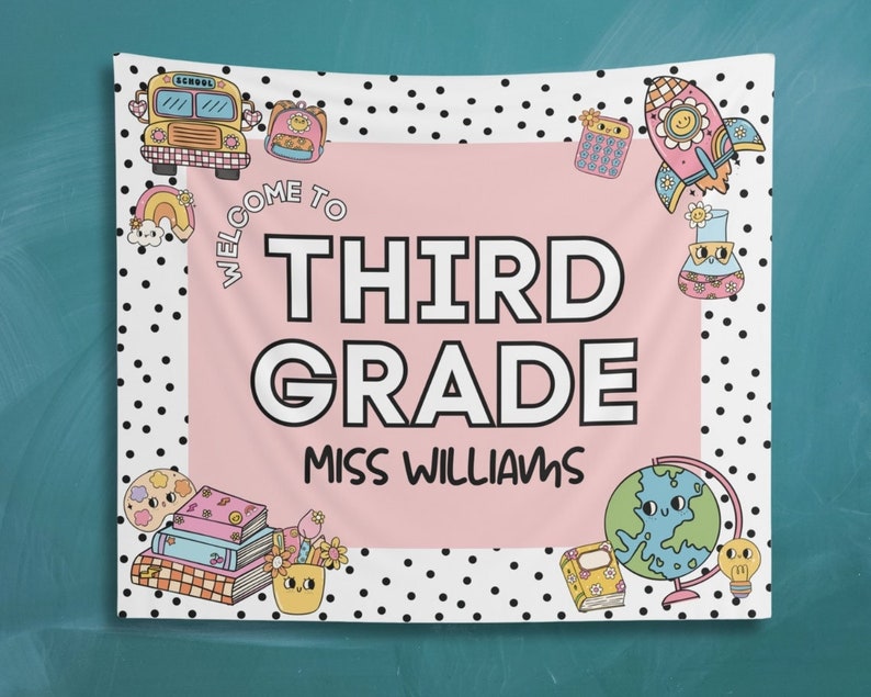 May include: A pink and white welcome banner with black polka dots. The banner says "Welcome to Third Grade Miss Williams". The banner has various illustrations including a school bus, a rocket, a globe, and books.
