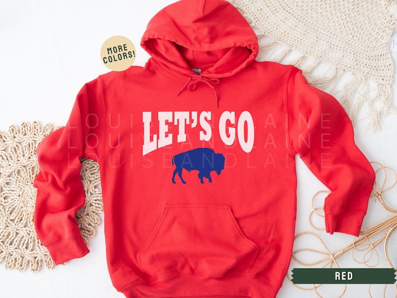 May include: Red hooded sweatshirt with the text "Let's Go" in white with a blue buffalo silhouette.