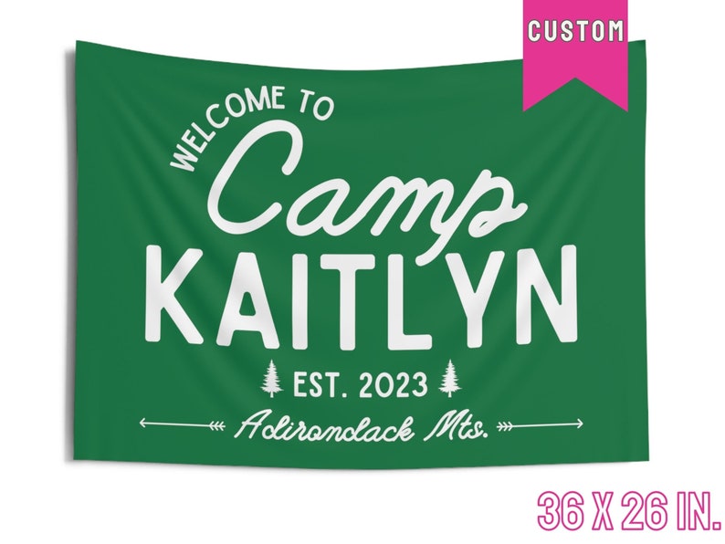May include: A green fabric banner with white text that reads "Welcome to Camp Kaitlyn Est. 2023 Adirondack Mts." The banner is 36 inches by 26 inches.
