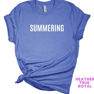 May include: A blue t-shirt with the word "SUMMERING" printed in white on the front.