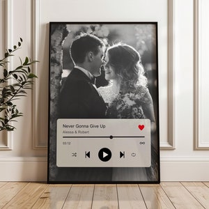May include: Black and white photograph of a couple in wedding attire, with a music player interface overlaid at the bottom. The music player shows the song "Never Gonna Give Up" by Alessia & Robert, with a play button and other controls.