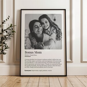 May include: Black and white photo of a woman and a girl hugging. The photo is framed and has a definition of "Bonus Mom" with the text "A loving individual who chooses to embrace another's child as her own. She provides support, protection, and encouragement with unwavering care and affection. A role model and friend, she builds bonds through shared experiences and mutual respect. Though not connected by blood, she enriches the family, showing that being a parent is about the heart, not DNA. Deeply loved and admired, she is a true hero. Synonyms: Superwoman, angel, protector, warrior"