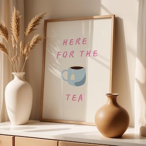 Op de afbeelding: Een witte keramische mok met een zwarte handgreep en de tekst "But First, Coffee" in een vetgedrukte, zwarte letter. De mok staat tegen een vage achtergrond. De mok is ongeveer 10 cm hoog.