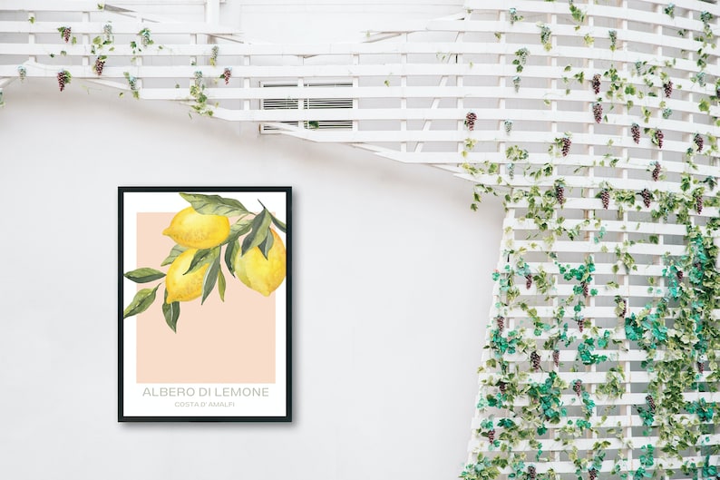Op de afbeelding: Een ingelijst print met een aquarel-illustratie van een tak van een citroenboom met drie citroenen. De achtergrond is licht perzikkleurig. De tekst "ALBERO DI LIMONE" en "COSTA D'AMALFI" is onder de illustratie gedrukt.