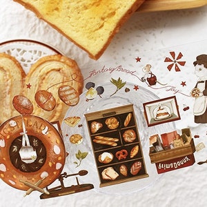 Op de afbeelding: Een set decoratieve stickers met een bakkersthema. De stickers bevatten afbeeldingen van brood, gebak, een bakkerijgevel, een windmolen, een muis en een vrouw in bakkerskleding. De stickers zijn gedrukt op transparant plastic en hebben een glanzende afwerking.