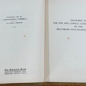 K&ouml;nnte beinhalten: Die aufgeschlagenen Seiten eines Buches zeigen links die Copyright-Informationen von 1907 von J. Montgomery Gambrill und rechts eine Widmung an die Poe and Lowell Literary Societies des Baltimore Polytechnic Institute, mit The Athenaeum Press.