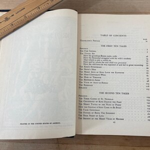 May include: Open book with a wooden ruler on top. The pages display a table of contents and text. The book is open to the first ten tales. The text "Printed in the United States of America" is visible.