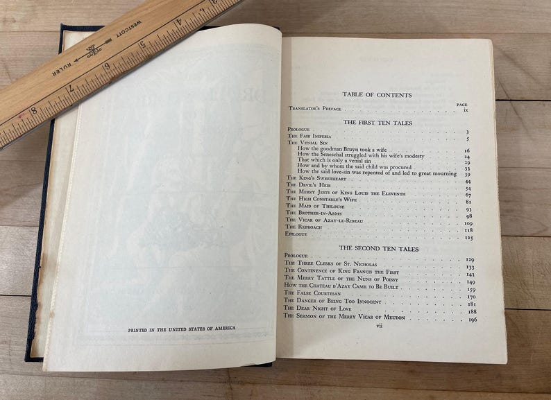 May include: Open book with a wooden ruler on top. The pages display a table of contents and text. The book is open to the first ten tales. The text "Printed in the United States of America" is visible.