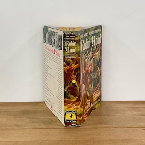 May include: A vintage copy of "The Merry Adventures of Robin Hood" by Howard Pyle. The book has a colorful cover illustration of Robin Hood and his men. The spine displays the title and author's name. The book is from the "Thrushwood Books" series.