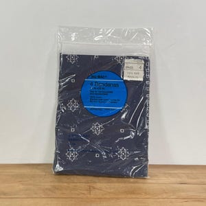 May include: A package of four navy blue bandanas, each measuring 24 x 22 inches. The bandanas feature a white floral and geometric pattern. The package includes a blue label with product information.