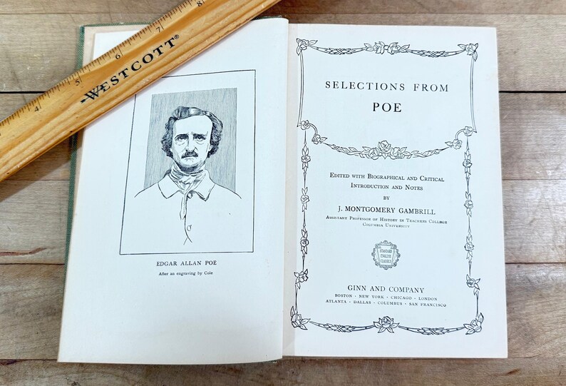K&ouml;nnte beinhalten: Ein aufgeschlagenes Buch mit dem Titel Selections from Poe, herausgegeben von J. Montgomery Gambrill, mit einem Portr&auml;t von Edgar Allan Poe auf der linken Seite. Ein h&ouml;lzernes Westcott-Lineal liegt diagonal dar&uuml;ber und zeigt Ma&szlig;e in Zentimetern.