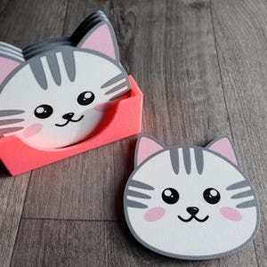 漫画猫の顔のコースター。ホルダー付き 4 枚セット。グレー、ホワイト、ピンク、ブラック。約 10 cm x 10 cm x 厚さ 0.3 cm。PLA で 3D プリント。