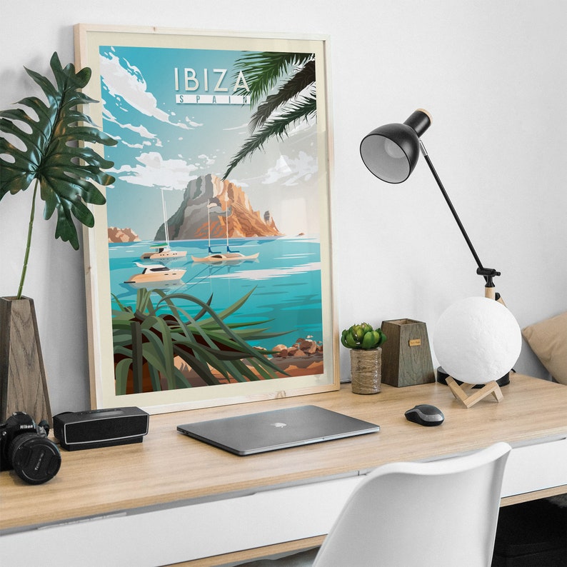 Pode incluir: Um p&ocirc;ster emoldurado com uma ilustra&ccedil;&atilde;o de viagem retr&ocirc; de Ibiza, Espanha. O p&ocirc;ster apresenta um oceano azul, uma ilha rochosa e veleiros. O texto "IBIZA ESPANHA" est&aacute; impresso em branco sobre um fundo azul.