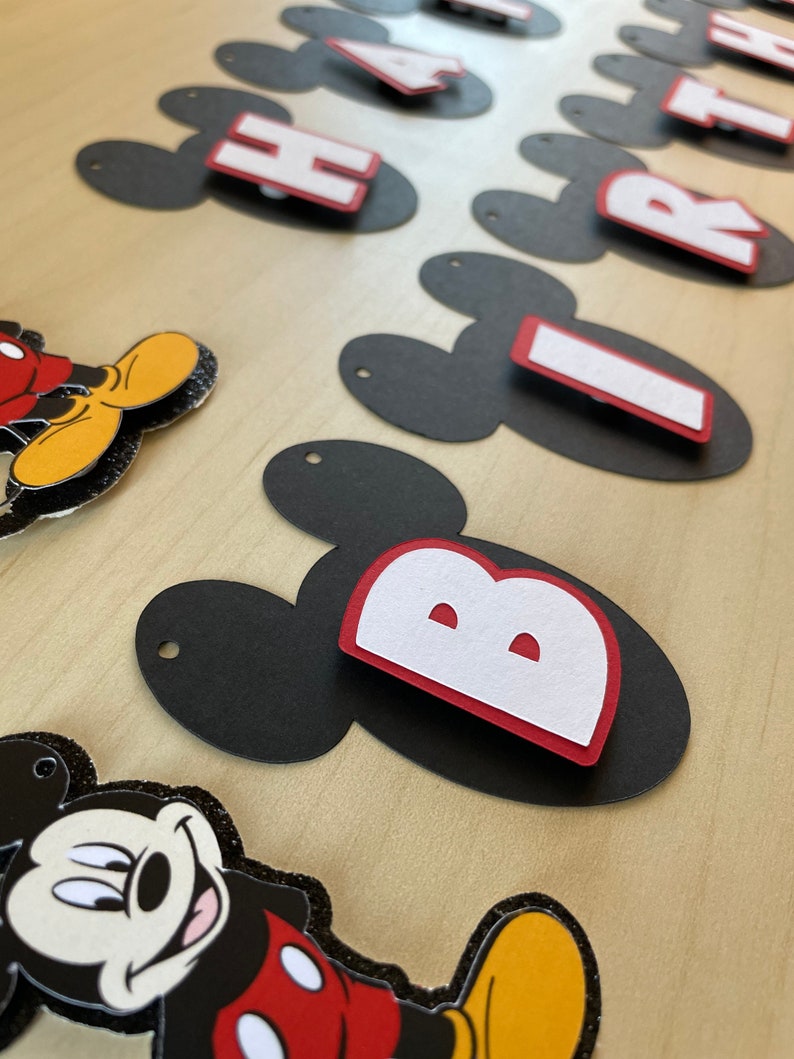May include: Black and red Mickey Mouse themed banner with the words "Happy Birthday" in white letters.