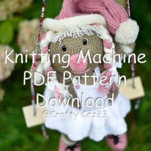 May include: Knitting machine PDF pattern download, a knitted doll wearing a pink hat and white dress, sitting on a swing. The doll has brown eyes and a pink nose. The text "Knitting Machine PDF Pattern Download @Crafty Caz33" is visible on the image.