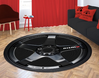 May include: Black and white round rug with a large black tire rim design. The tire rim has the word "NISMO" printed in white on the side.