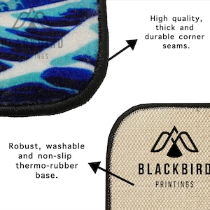 K&ouml;nnte beinhalten: Nahaufnahme eines blauen und wei&szlig;en Teppichs mit Muster und schwarzem Rand. Der Teppich hat eine rutschfeste Thermopgummi-Unterseite. Der Teppich wird von Blackbird Printings hergestellt.
