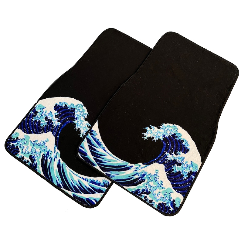 K&ouml;nnte beinhalten: Zwei schwarze Fu&szlig;matten mit einem blauen und wei&szlig;en Wellendesign. Das Wellendesign ist ein japanischer Kunstdruck.