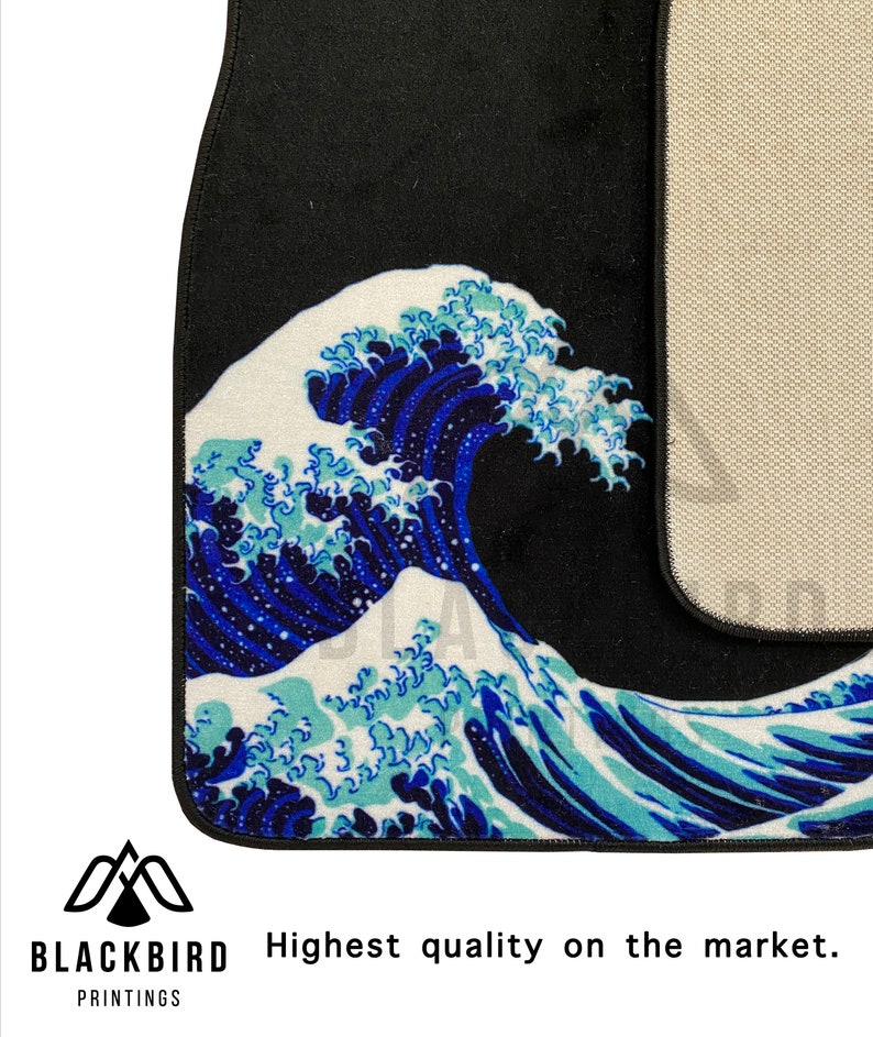 K&ouml;nnte beinhalten: Eine schwarze Autofu&szlig;matte mit einem blauen und wei&szlig;en Wellendesign. Die Matte hat eine rutschfeste R&uuml;ckseite.