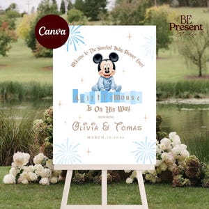 May include: A white rectangular baby shower welcome sign on a white easel featuring a cartoon baby Mickey Mouse in a blue outfit, blue firework graphics, and gold stars. Text reads: Welcome to The Sweetest Baby Shower Ever! A Little Mouse Is On His Way, Olivia & Tomas, March 15, 2026.