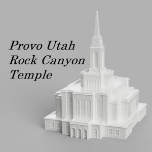 May include: White model of the Provo Utah Rock Canyon Temple. The temple is a white, detailed model with a tall spire.