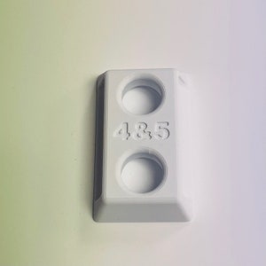 May include: White plastic wall mount with two round holes and the text "4&5" printed on the front.