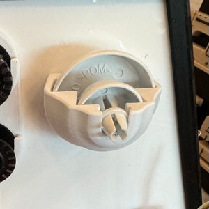 May include: White plastic sewing machine bobbin winder with a small white plastic pin and the text "POM" on the side.