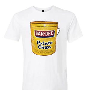 May include: White t-shirt featuring a vintage-style graphic of a yellow Dan-Dee Potato Chips can. The can design includes the brand name in a red and blue banner, with the words "Potato Chips" below. The shirt is a classic crew neck.