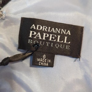 May include: A black and white label with the text "Adrianna Papell Boutique" and a smaller label that says "Made in China".