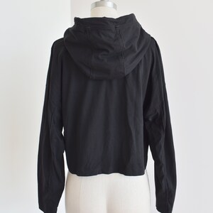 Black hoodie in lightweight t-shirt cotton, tonal piping along sleeves and chest, drawstring with silver endings