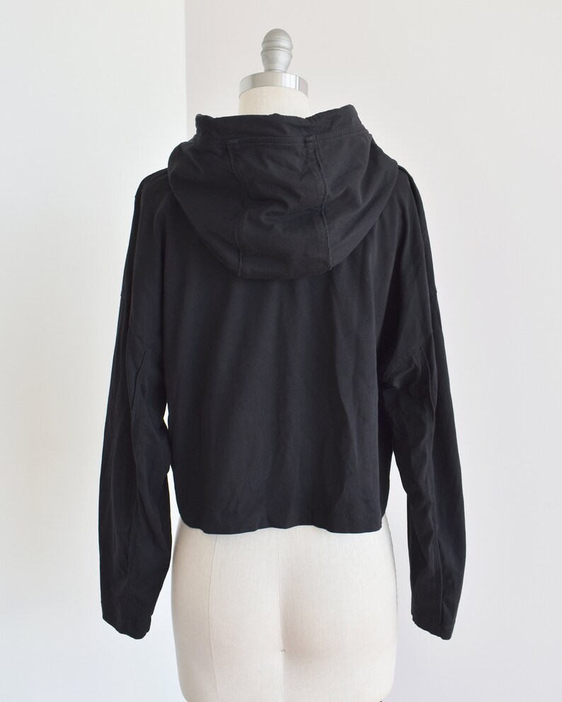 Black hoodie in lightweight t-shirt cotton, tonal piping along sleeves and chest, drawstring with silver endings